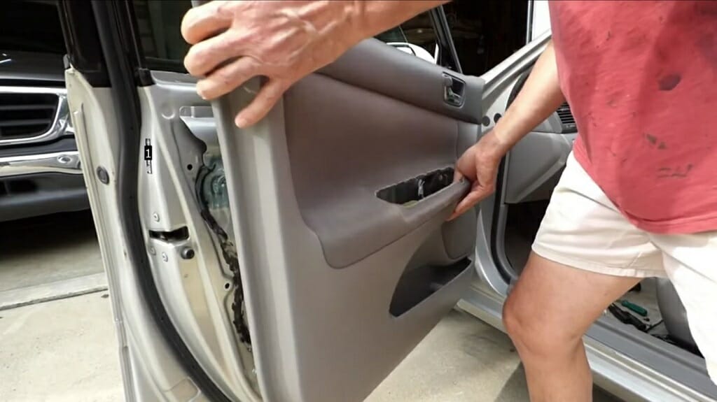 man pulling out the car door panel