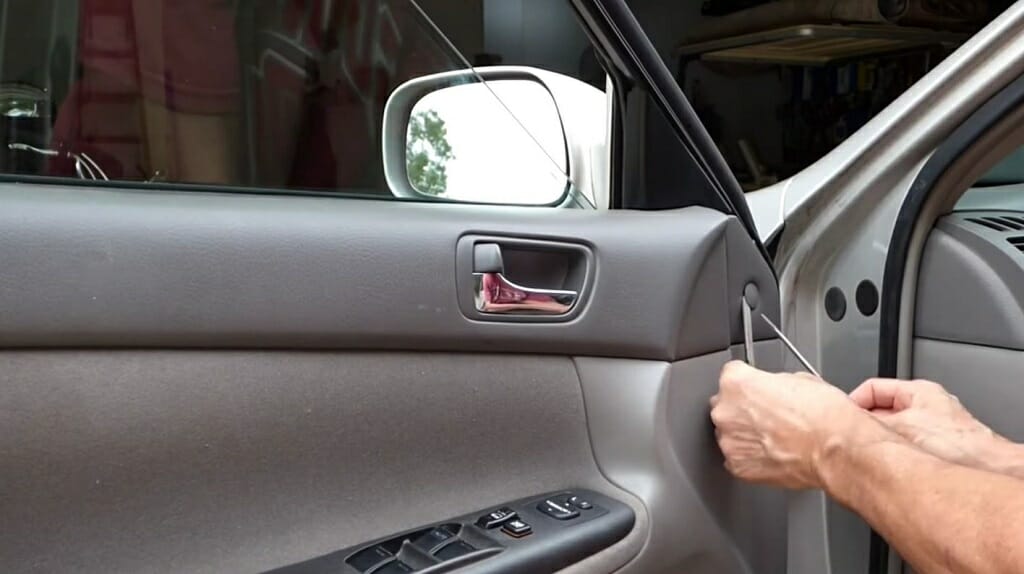 man removing the car door's plastic cover