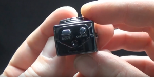 a man holding a mini camera showing the on and off button